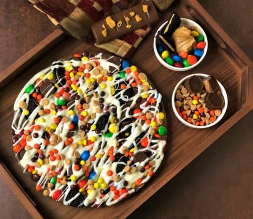 peanut butter avalanche chocolate pizza on wooden tray