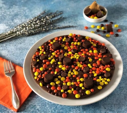 chocolate pizza topped with peanut butter candies and cups