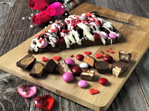 slice of chocolate pizza on wooden board with candy toppings offering serious temptations